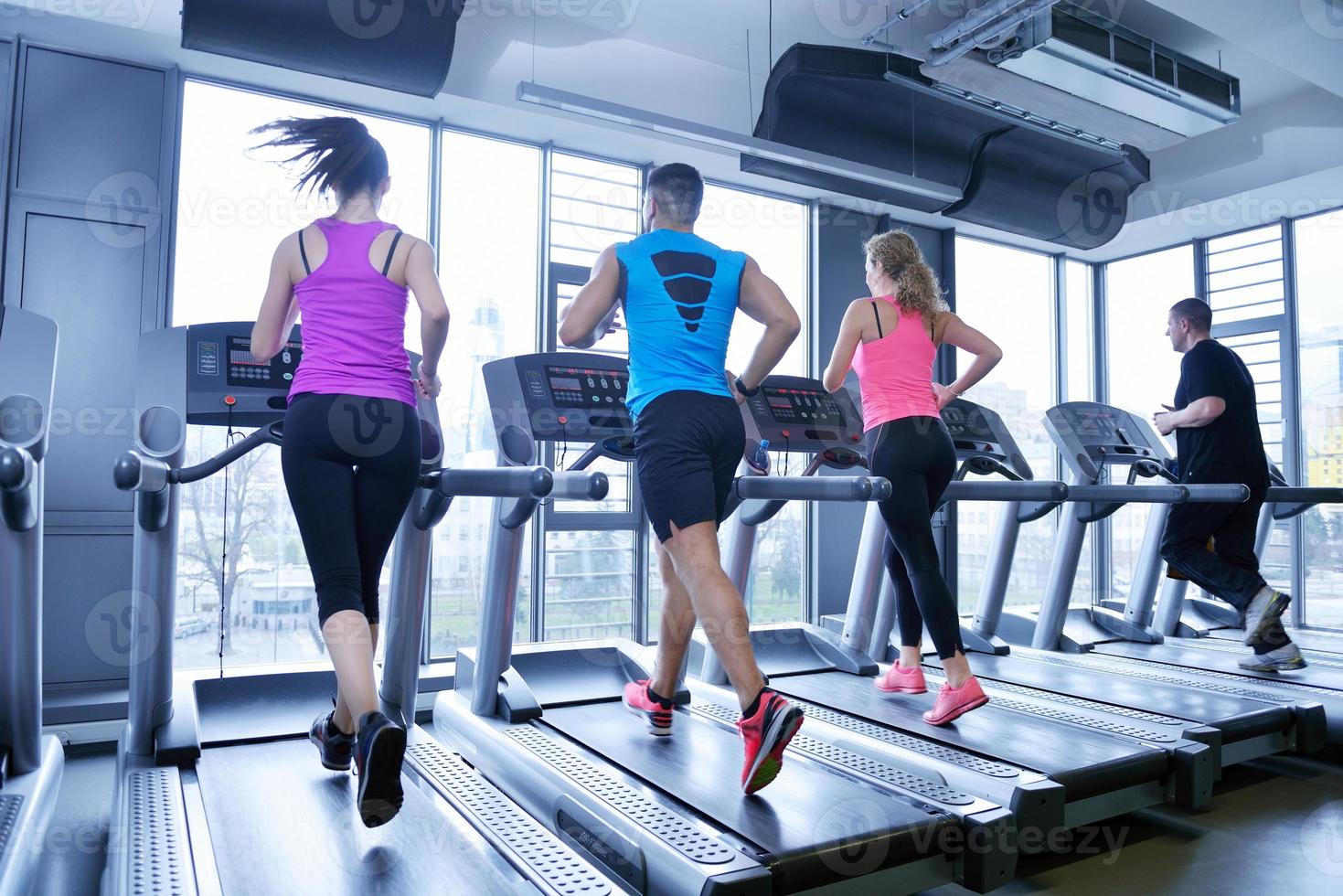 Group of people running on treadmills photo