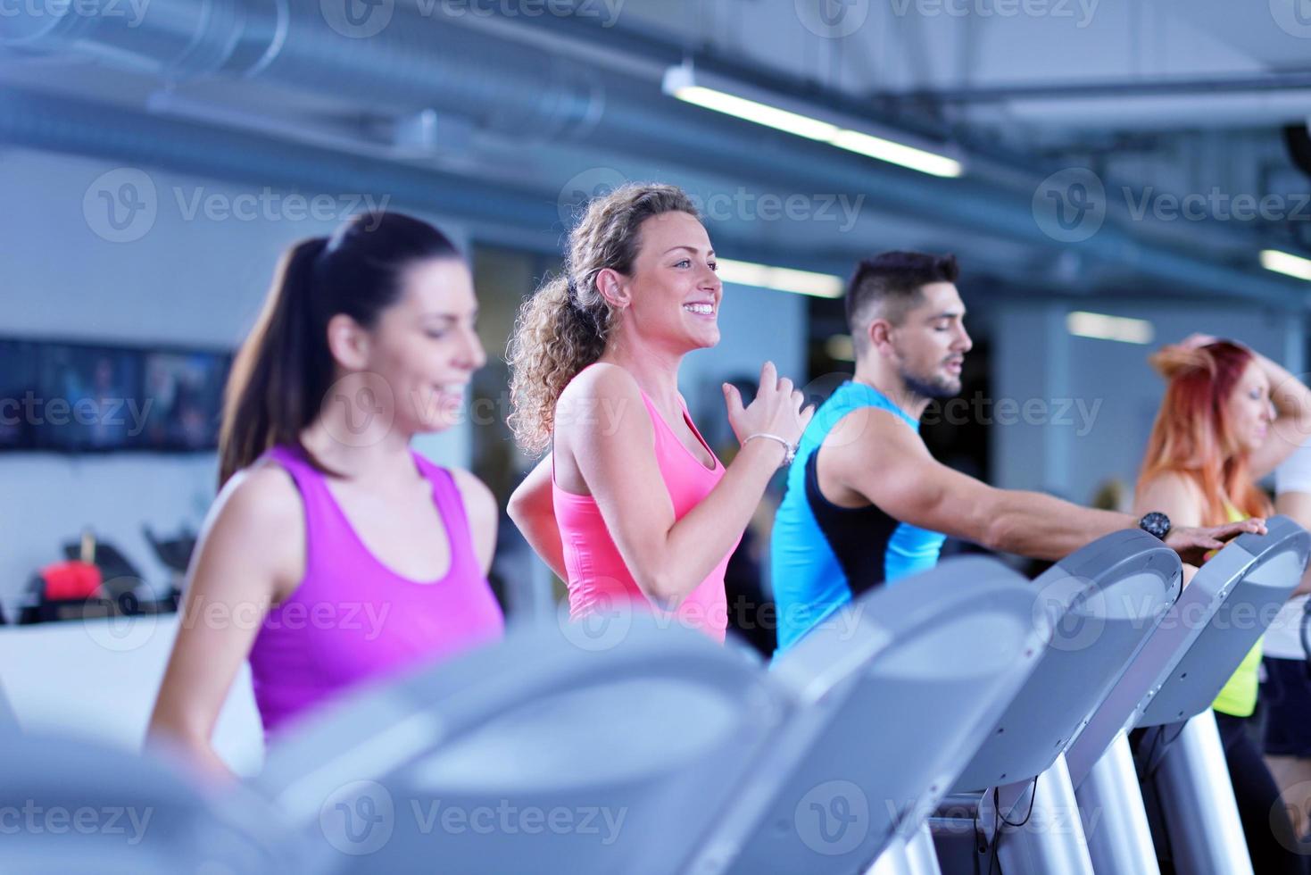 Group of people running on treadmills photo