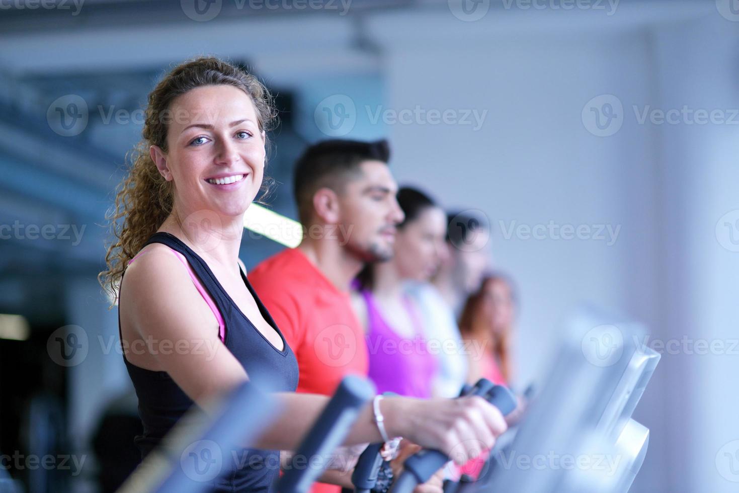 Group of people running on treadmills photo