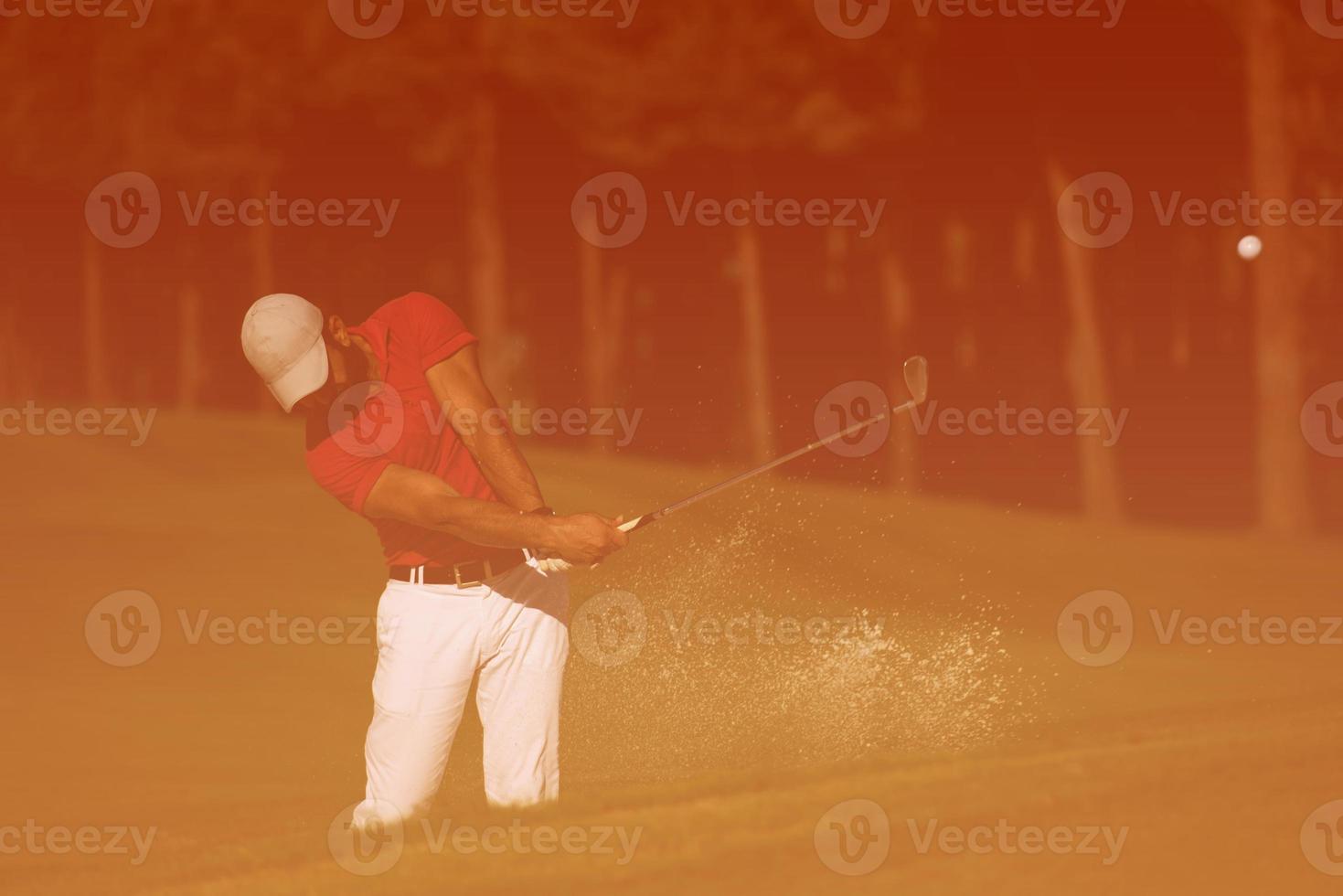 golfer hitting a sand bunker shot photo