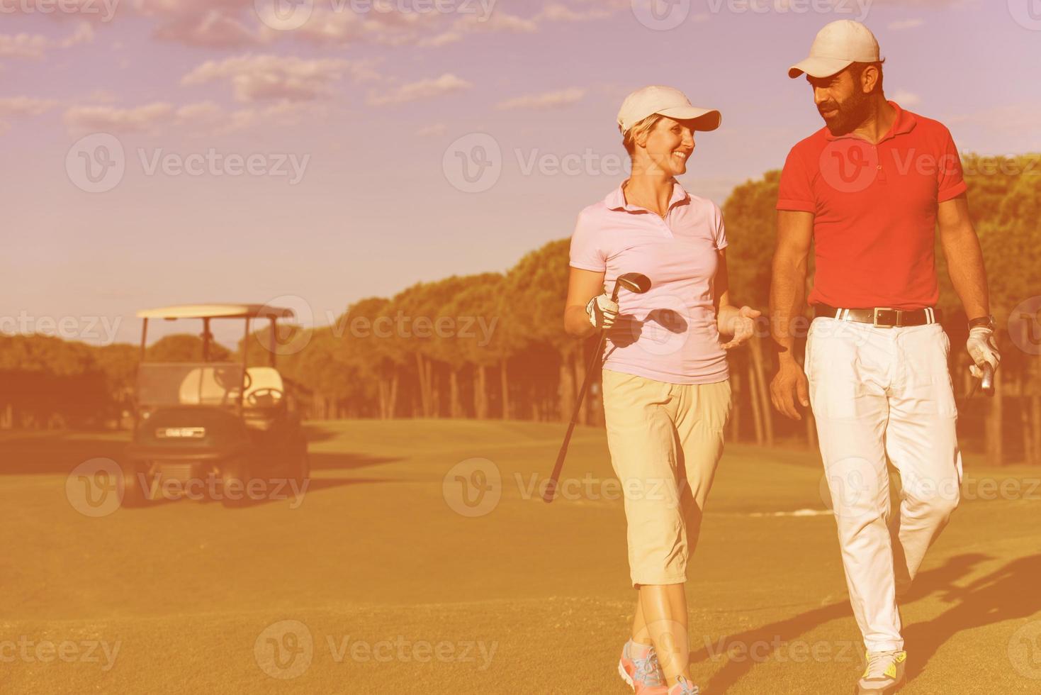 couple walking on golf course photo