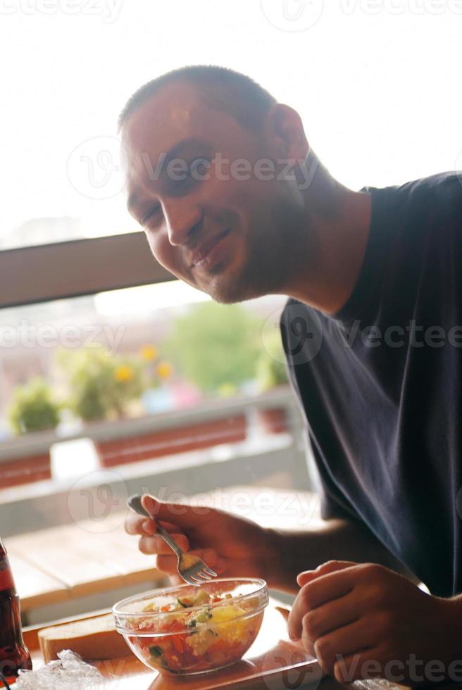 hombre comiendo comida saludable en un restaurante foto