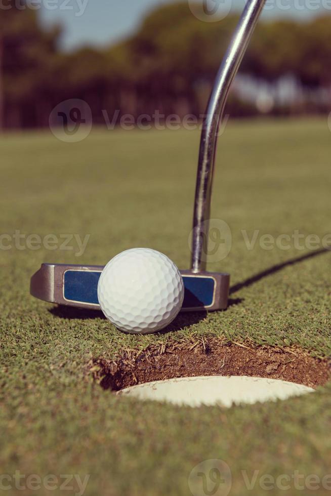 hitting golf ball to hole photo