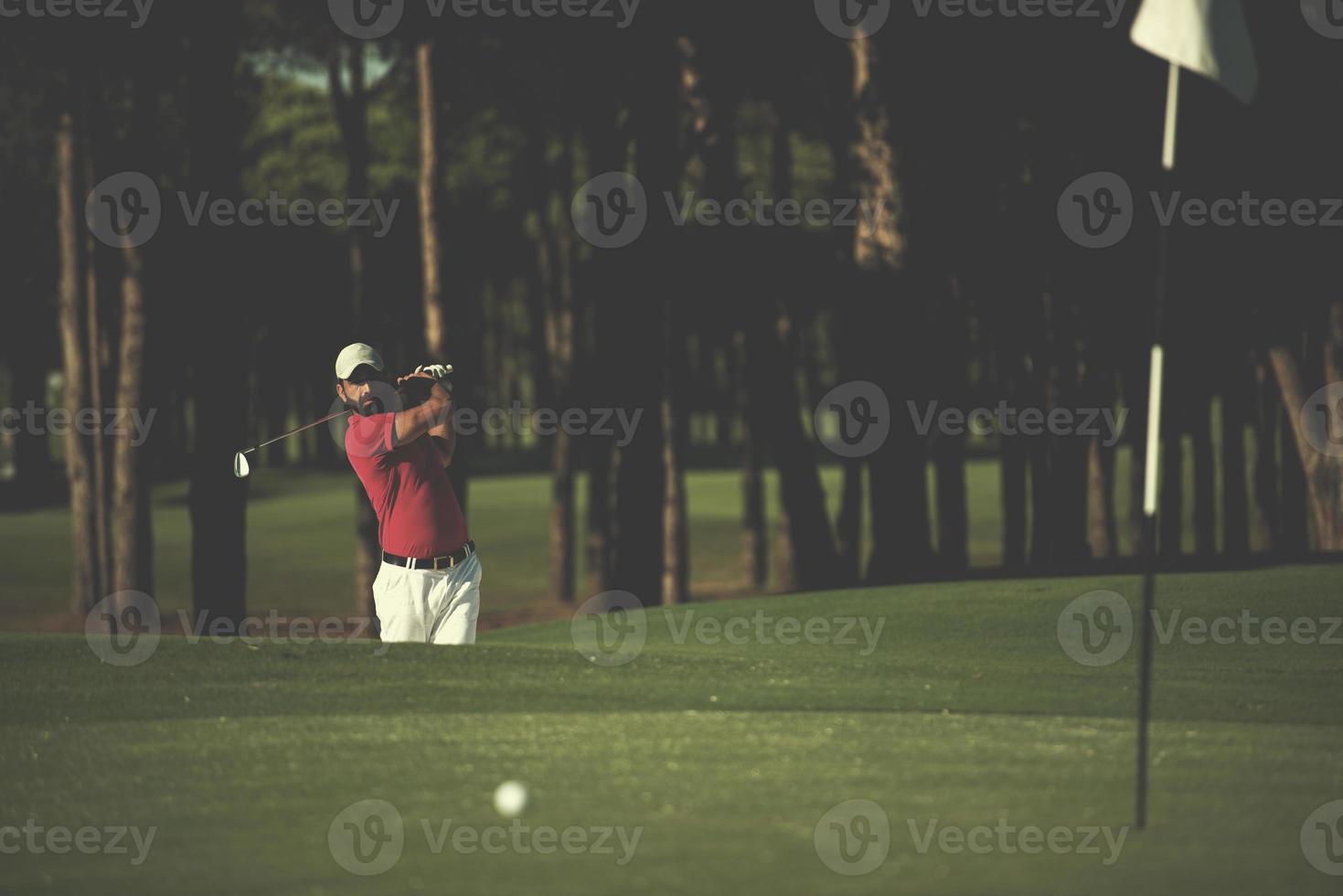 golfer hitting a sand bunker shot photo