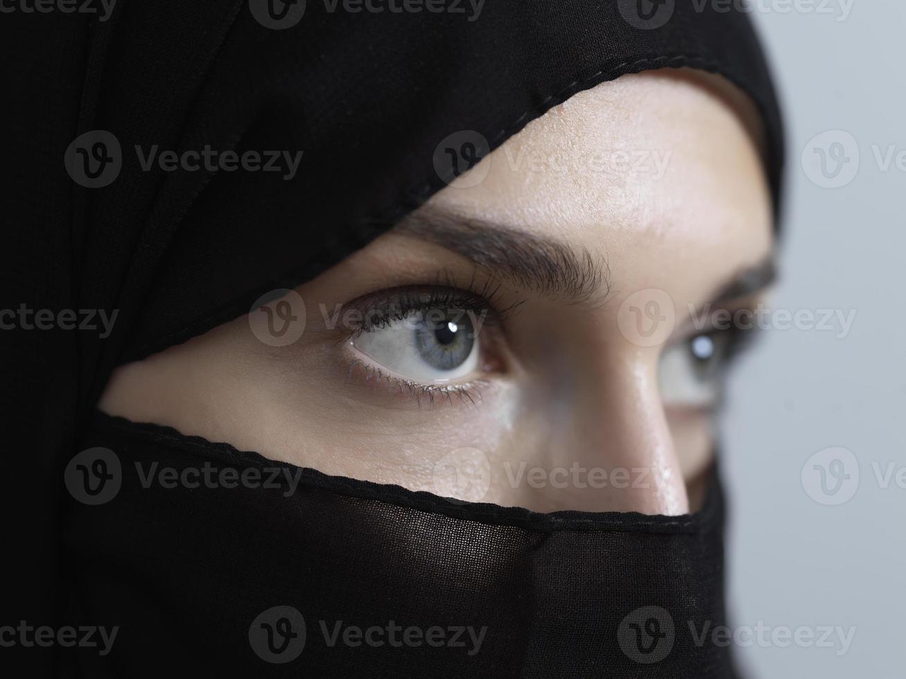 Portrait of muslim woman wearing niqab and traditional arabic clothes or abaya photo