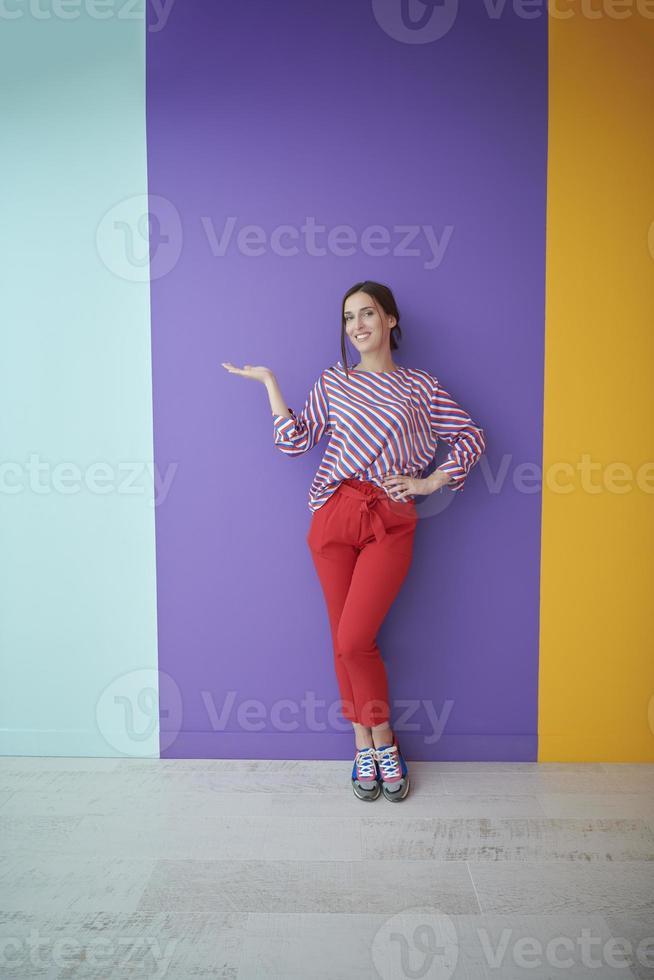 Portrait of happy smiling young beautiful woman in a presenting gesture with open palm photo