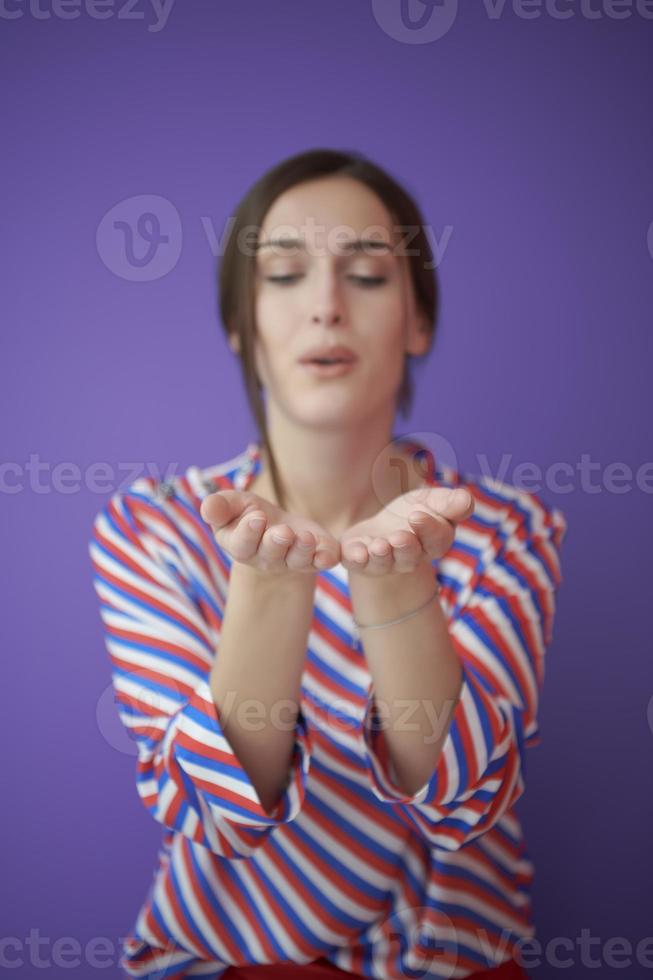 Close up portrait of charrming girl  blowing air kiss from open palm photo