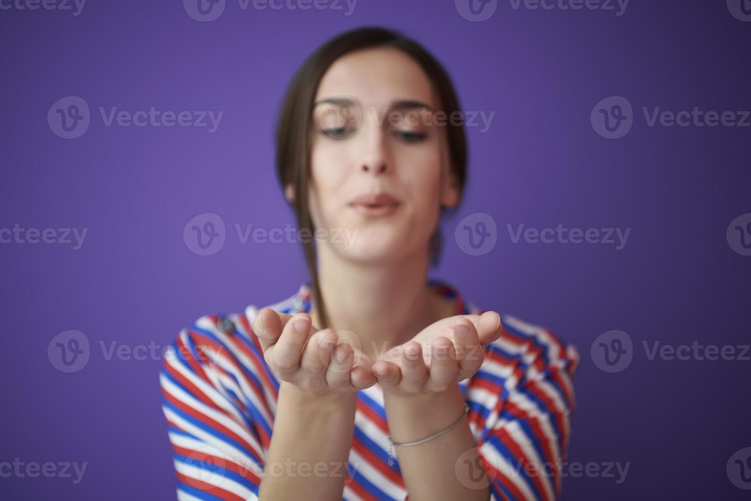 Close up portrait of charrming girl  blowing air kiss from open palm photo