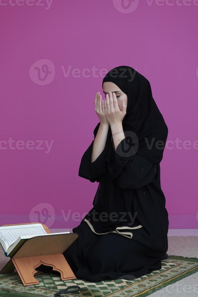 Middle eastern woman praying and reading the holy Quran photo