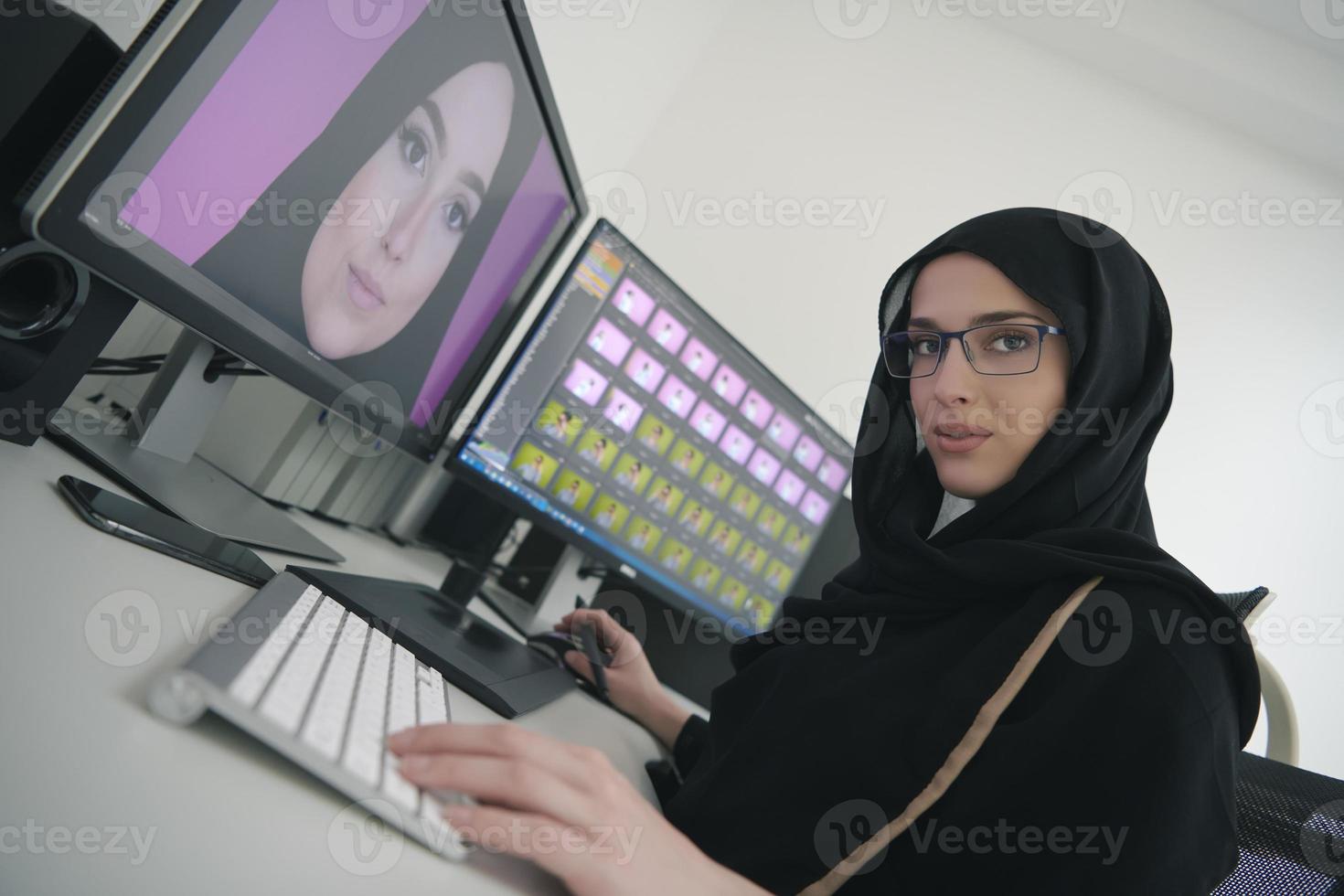 Young muslim girl working on the computer from home photo