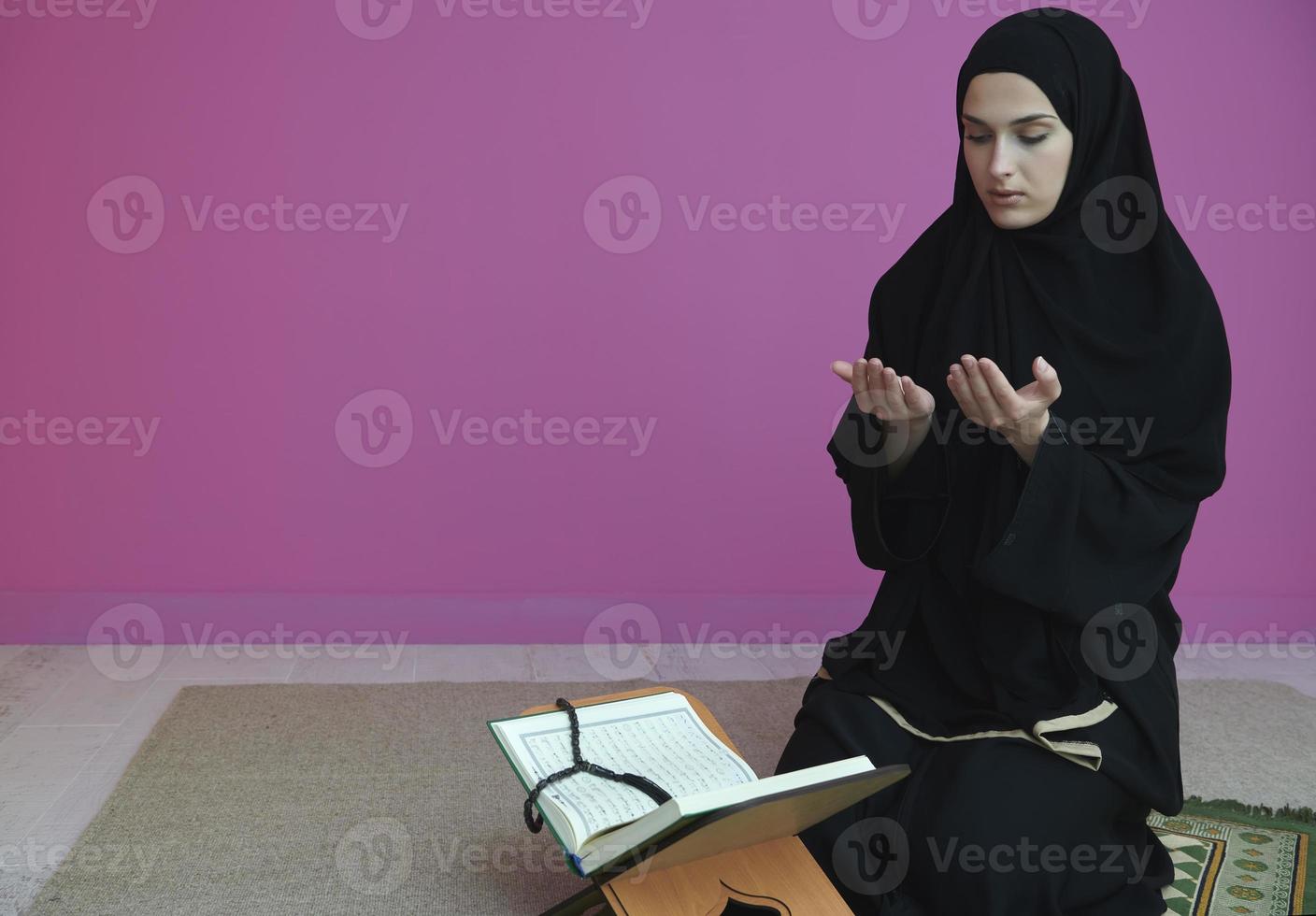 Middle eastern woman praying and reading the holy Quran photo