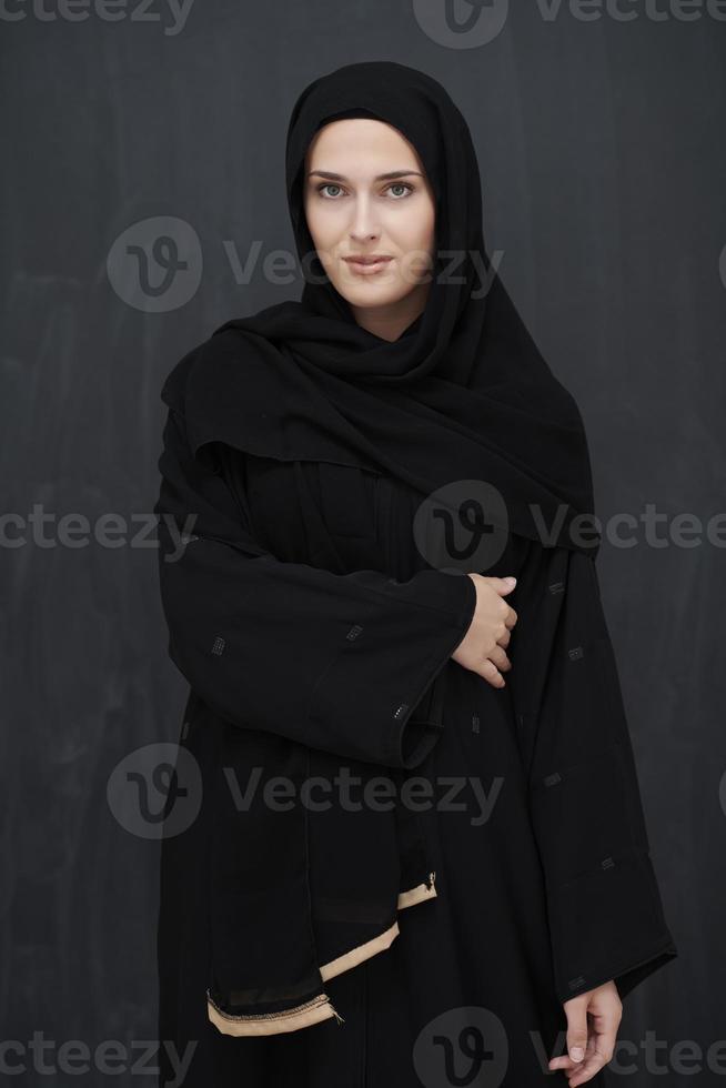 Modern young muslim woman in black abaya photo