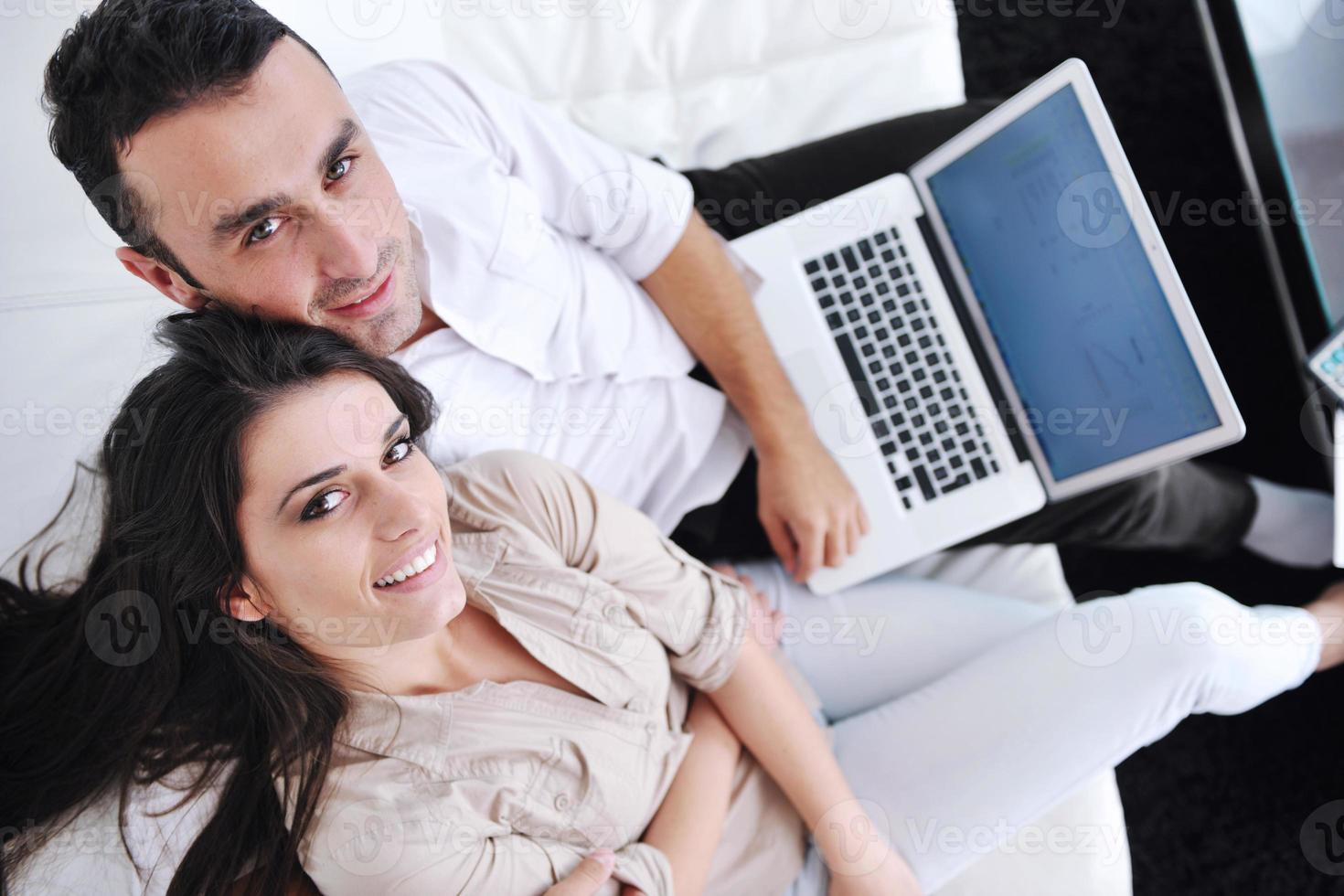 joyful couple relax and work on laptop computer at modern home photo