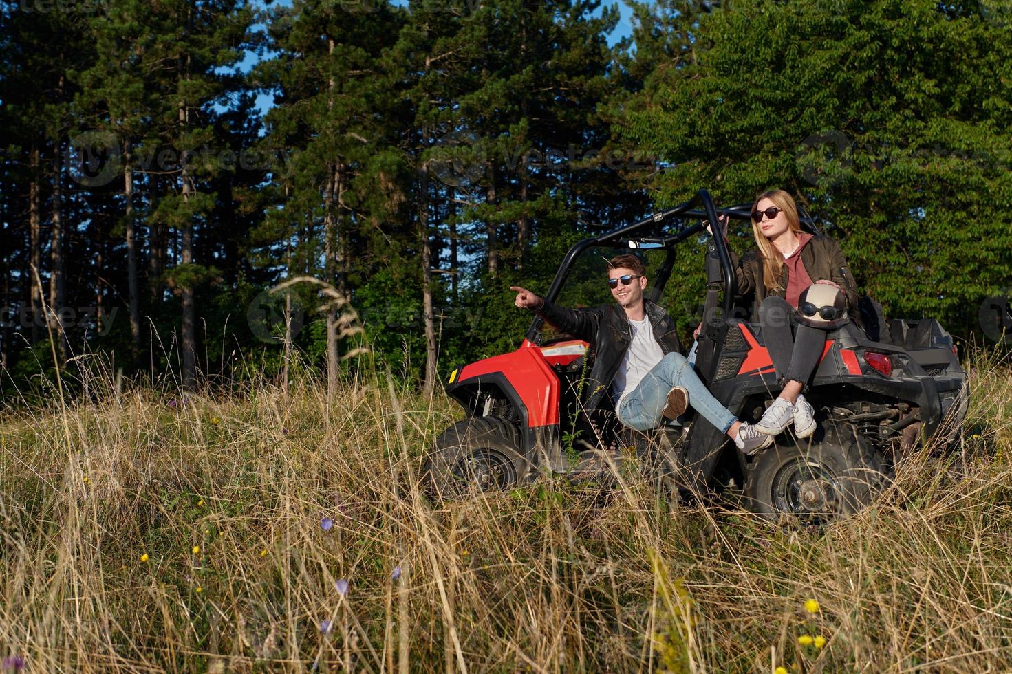 pareja disfrutando de un hermoso día soleado mientras conduce un buggy todoterreno foto