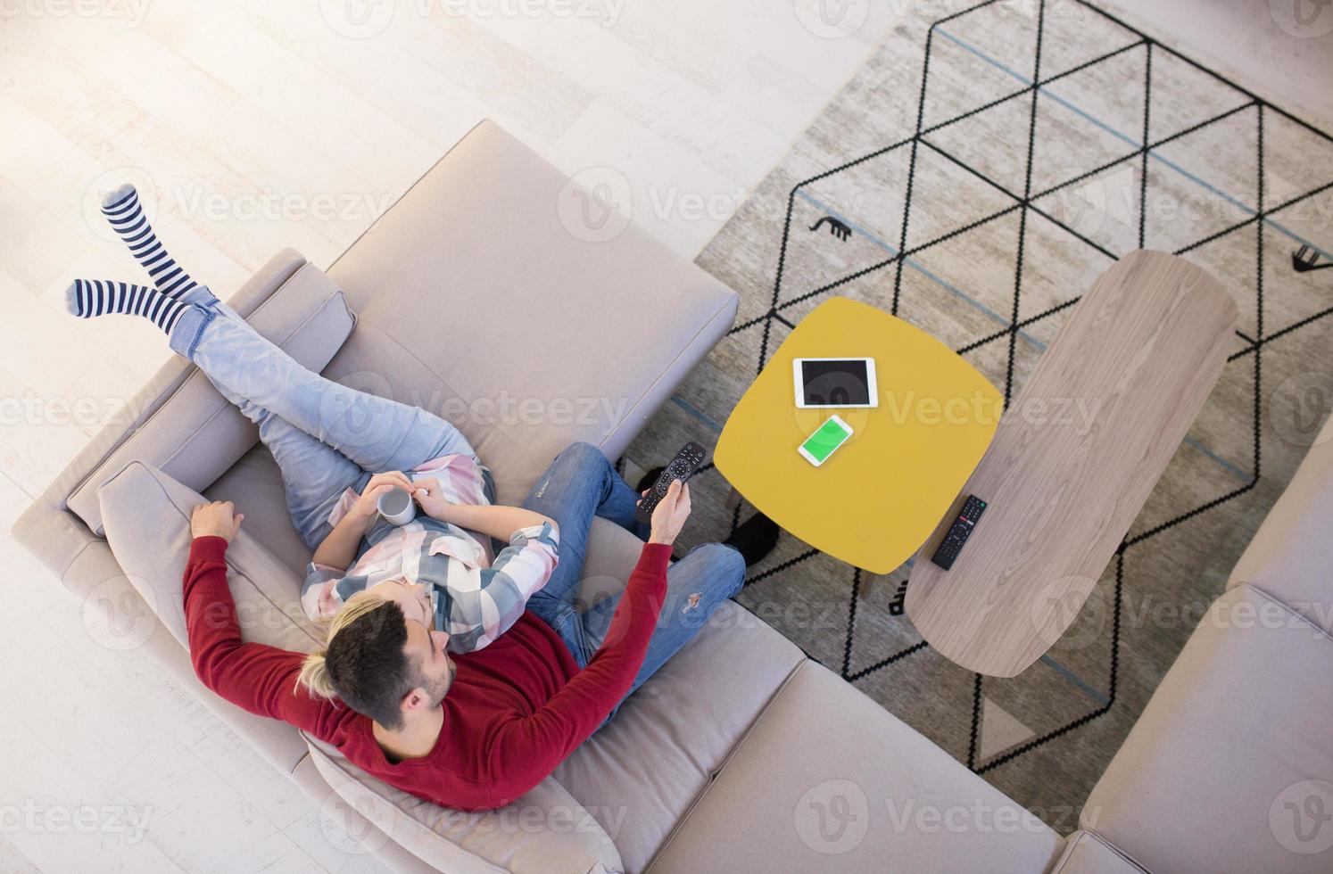 Young couple on the sofa watching television photo