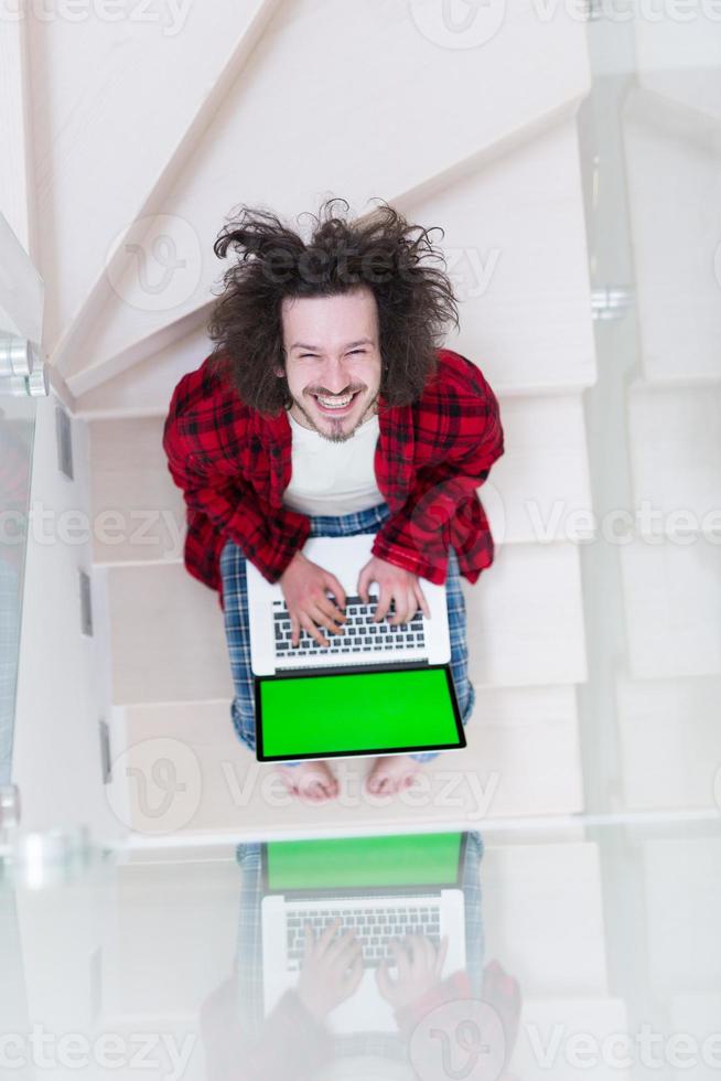 freelancer en bata de baño trabajando desde casa foto