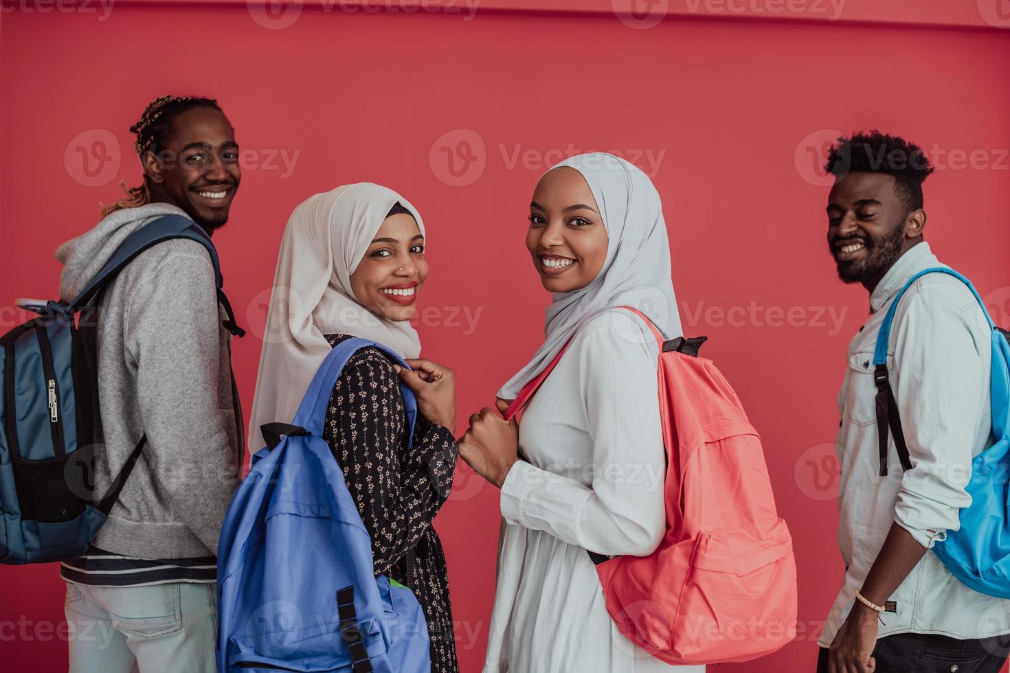 A group of African Muslim students with backpacks posing on a pink background. the concept of school education. photo