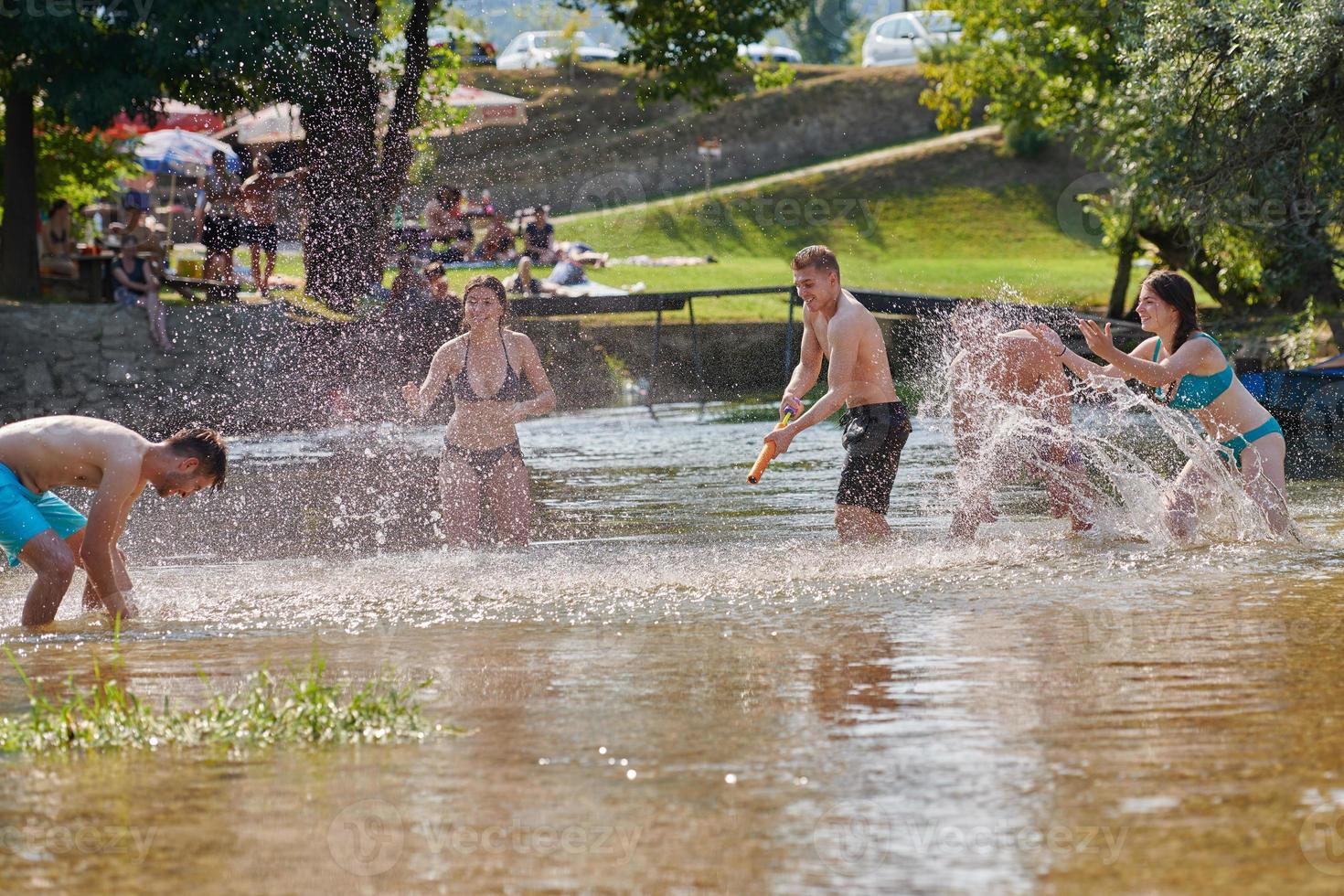 group of happy friends having fun on river photo