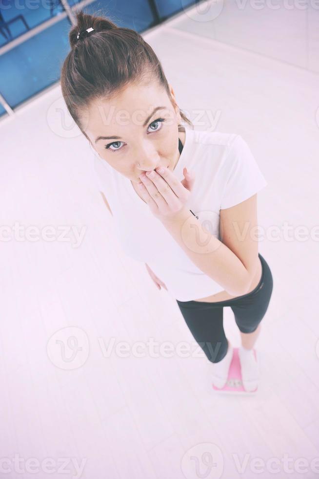 happy diet concept with young woman on pink scale photo