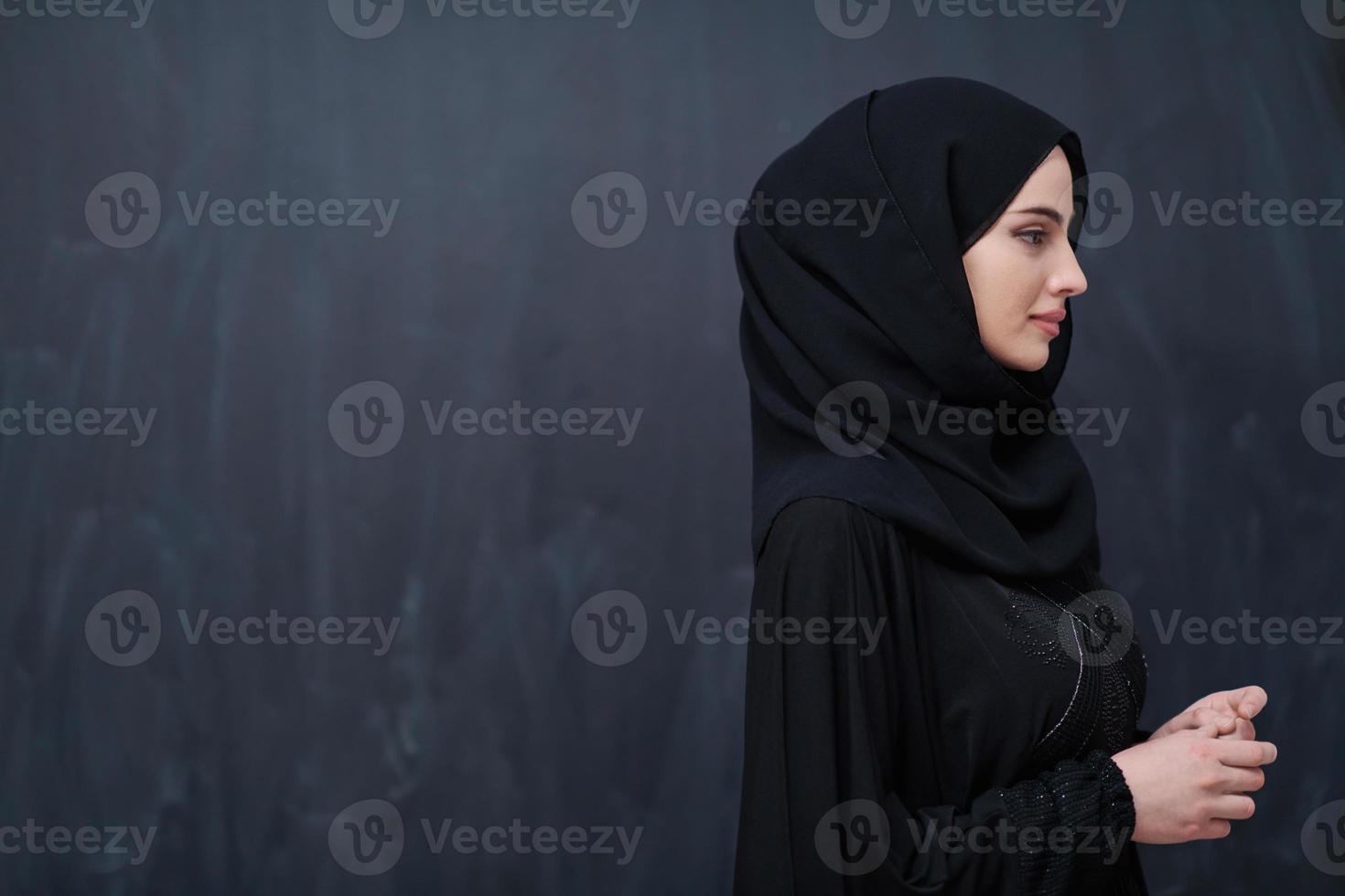 portrait of beautiful muslim woman in front of black chalkboard photo