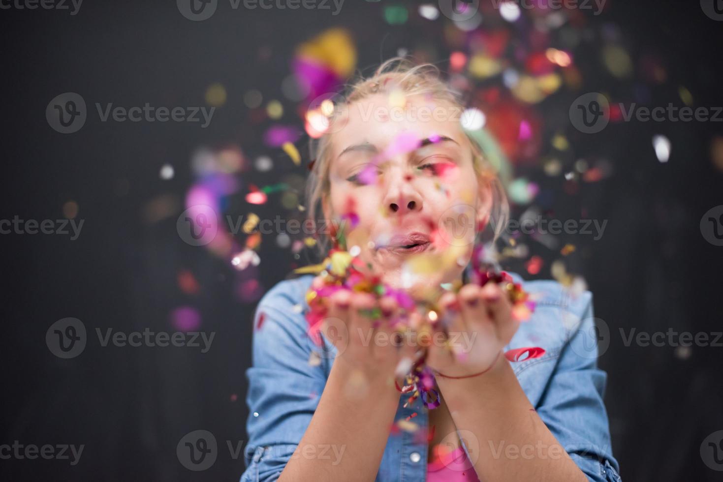 woman blowing confetti in the air photo