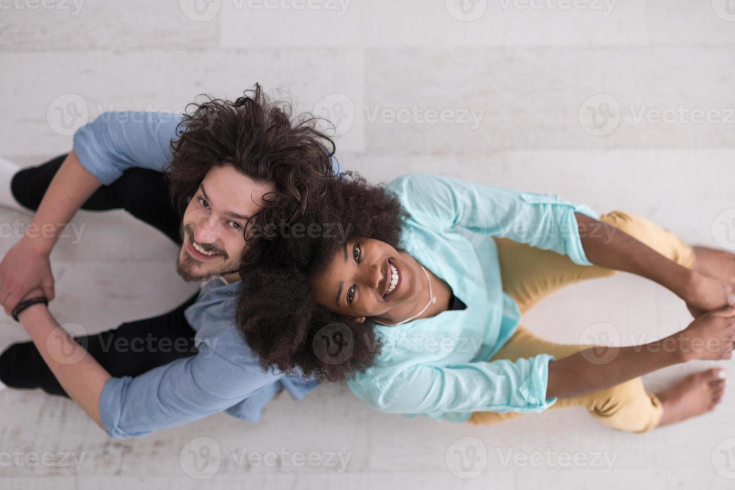 vista superior 0f alegre joven pareja multiétnica sentada foto