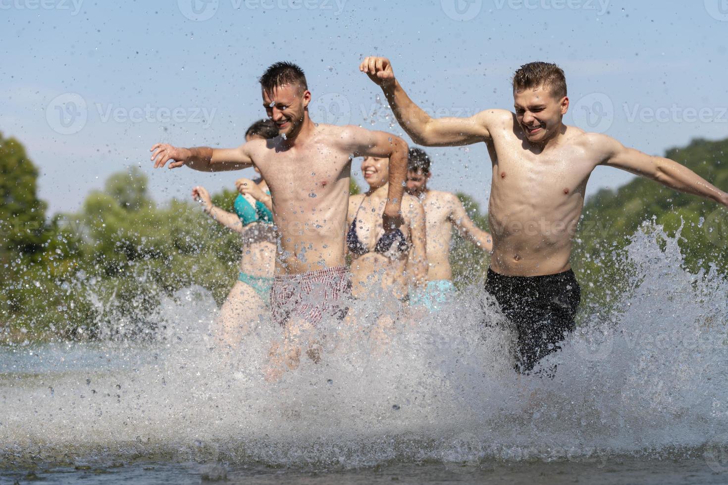group of happy friends having fun on river photo