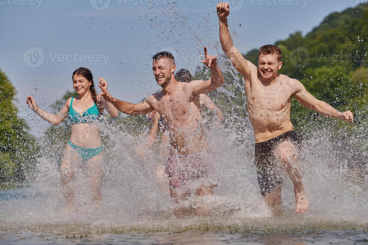 group of happy friends having fun on river photo