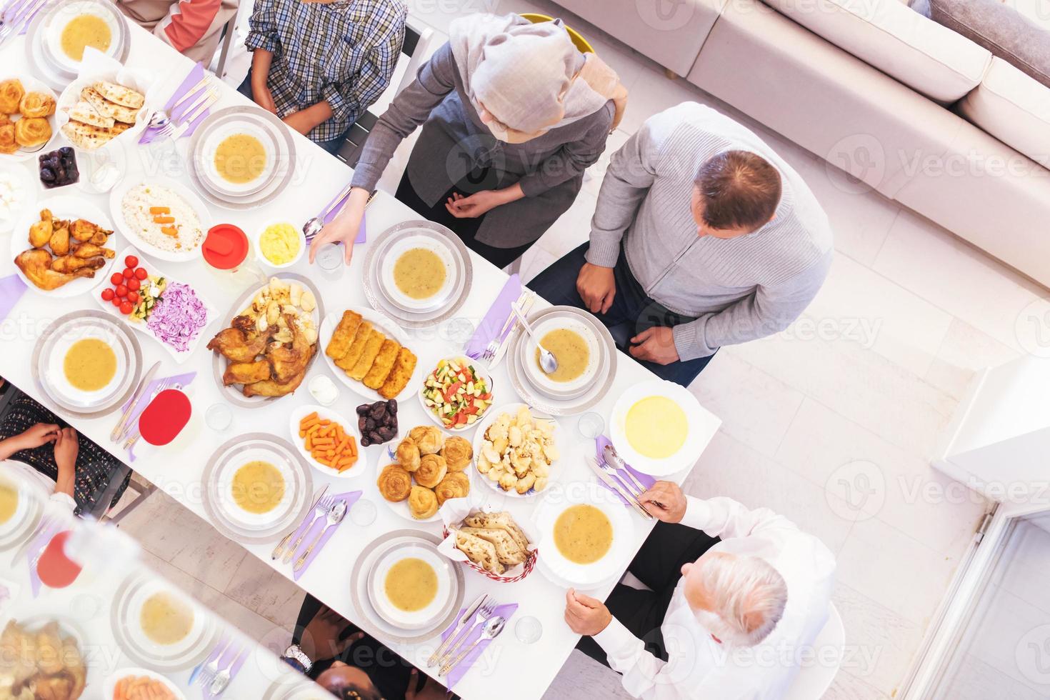 top view of modern multiethnic muslim family waiting for the beginning of iftar dinner photo
