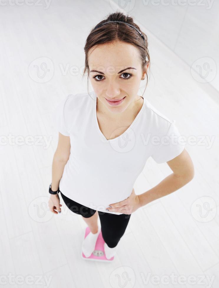 happy diet concept with young woman on pink scale photo