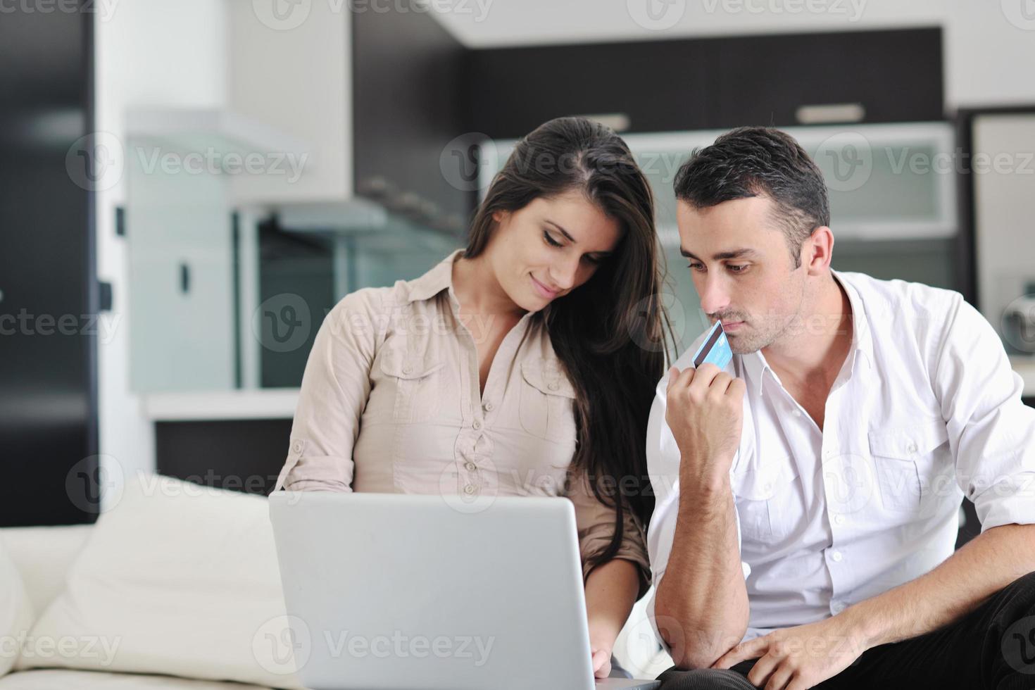 joyful couple relax and work on laptop computer at modern home photo