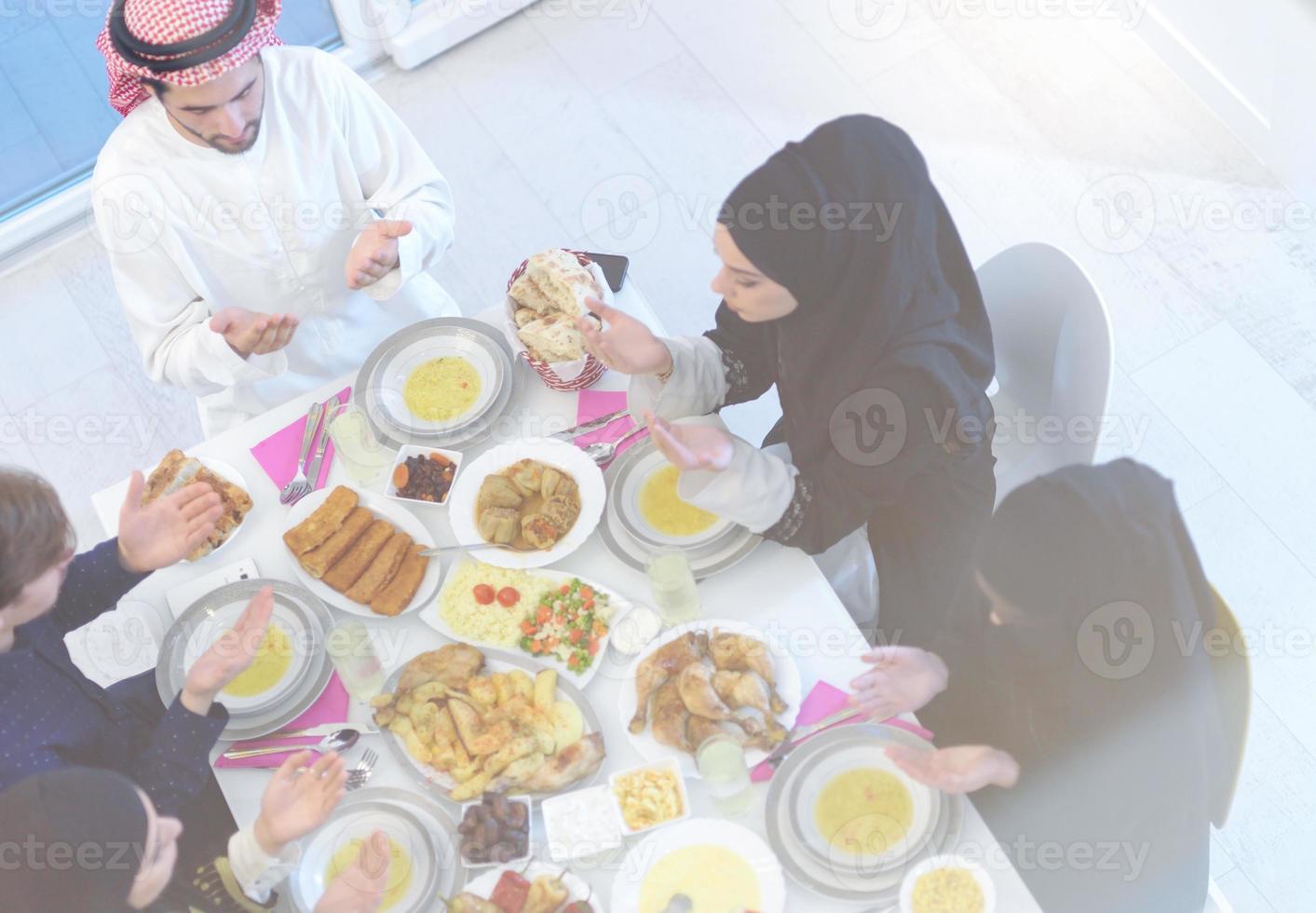 familia musulmana tradicional rezando antes de la cena iftar foto