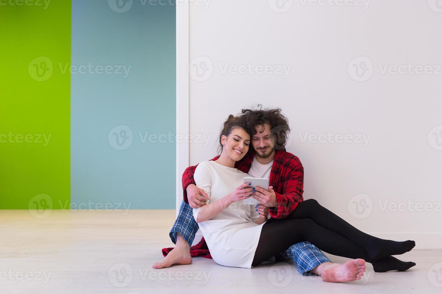 pareja joven usando tableta digital en el piso foto