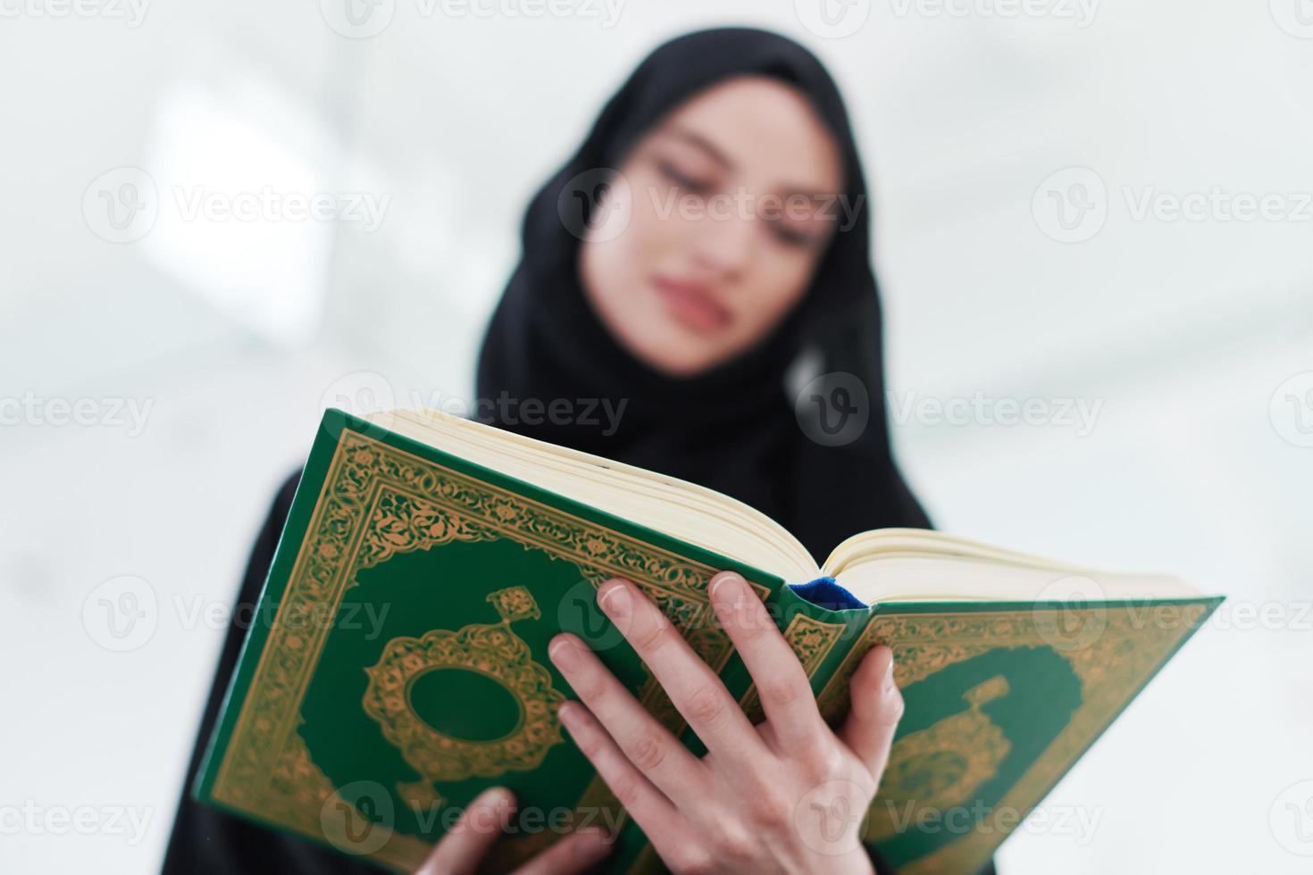 young muslim woman reading Quran at home photo