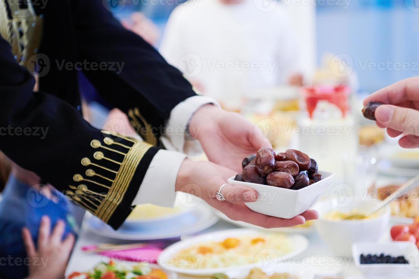 Muslim family having Iftar dinner eating dates to break feast photo