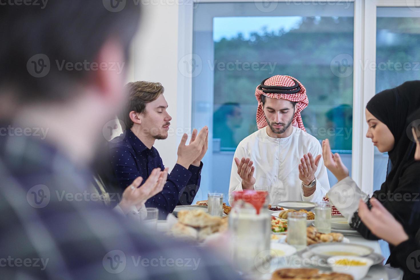 Muslim family making iftar dua to break fasting during Ramadan. photo
