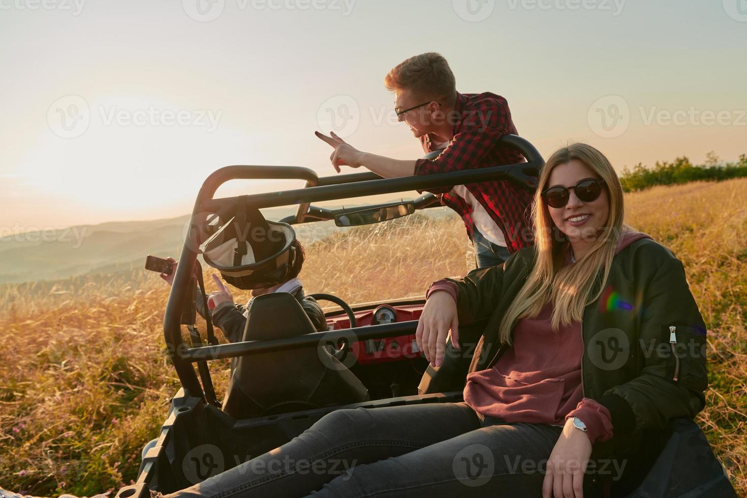 group young happy people enjoying beautiful sunny day while driving a off road buggy car photo
