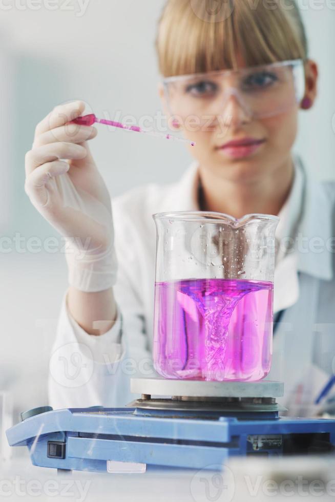 female researcher holding up a test tube in lab photo