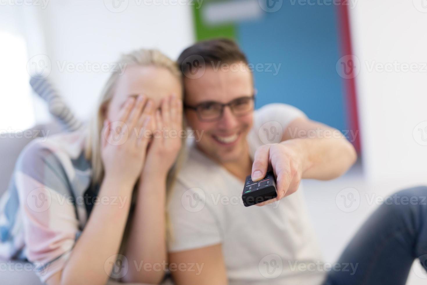 Young couple on the sofa watching television photo