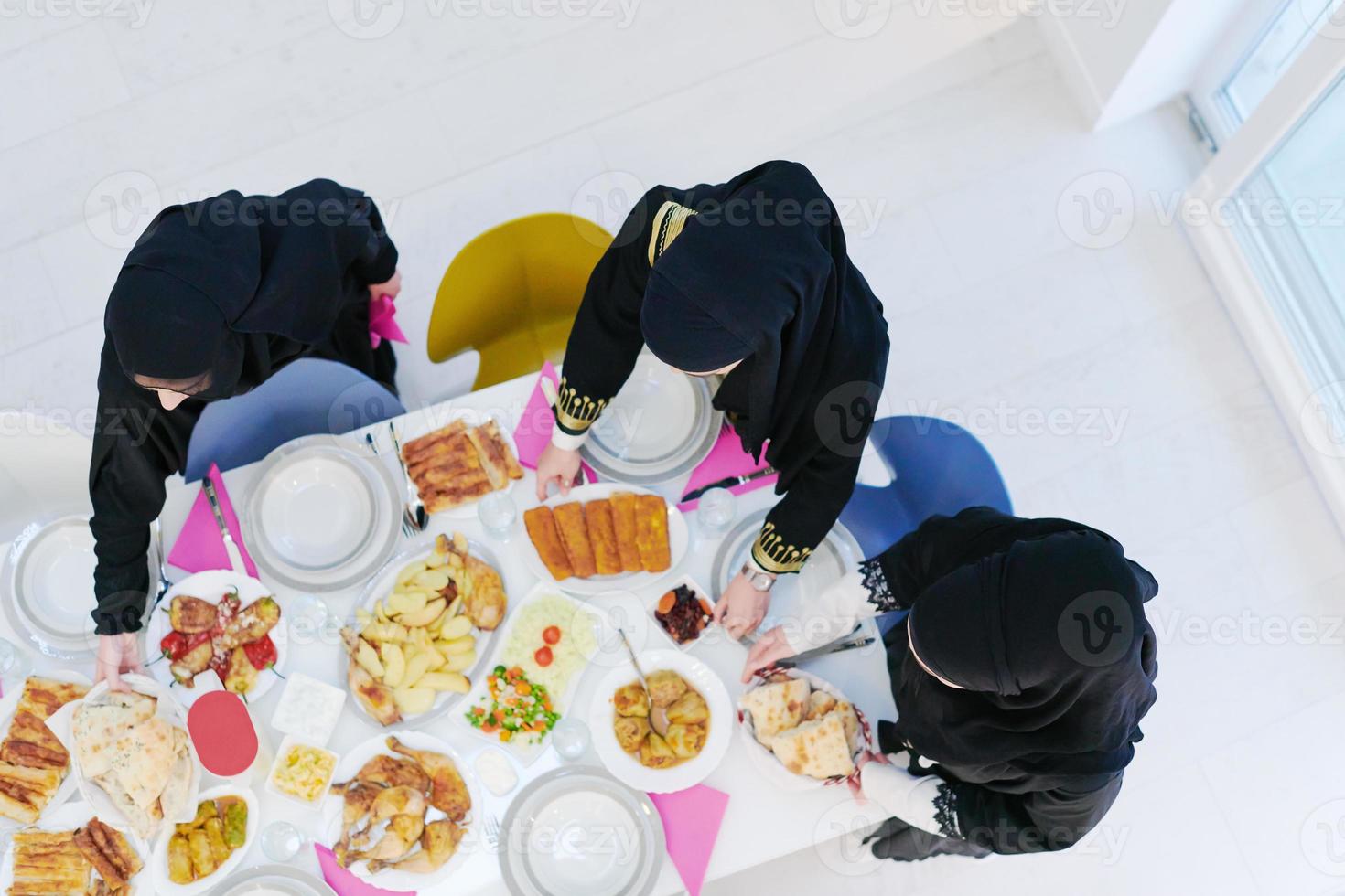 young muslim girls serving food on the table for iftar dinner top view photo