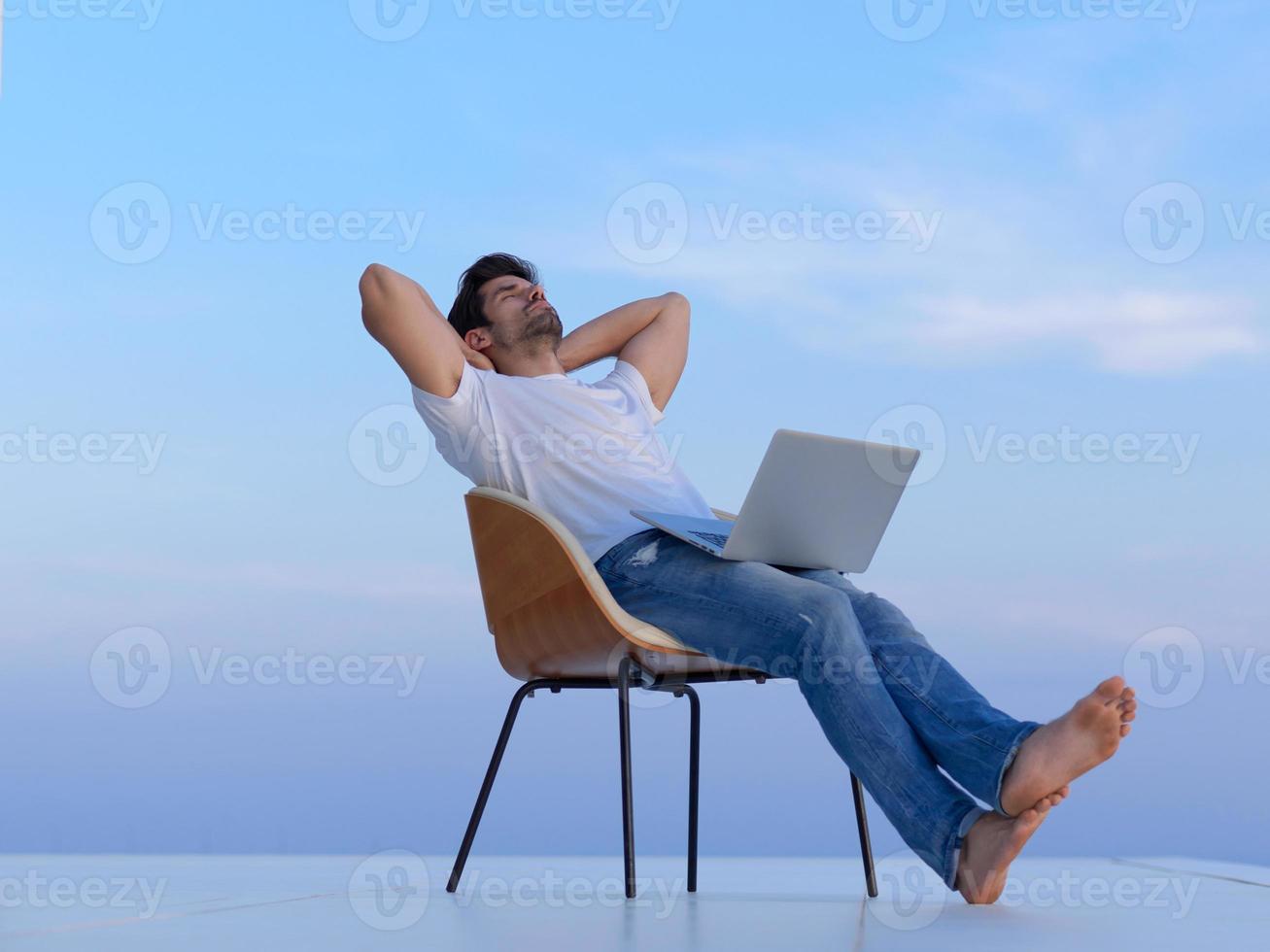 relaxed young man at home on balcony photo