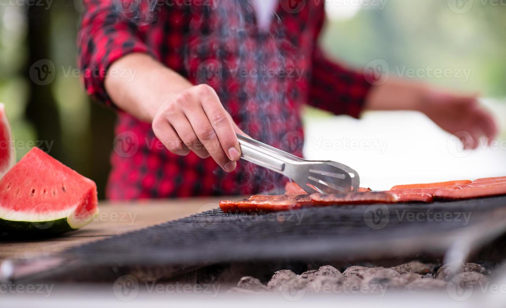 Man cooking tasty food on barbecue grill photo