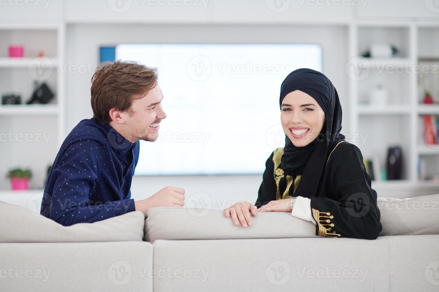 young muslim couple watching TV together photo