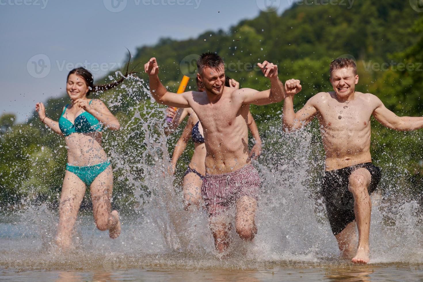 group of happy friends having fun on river photo