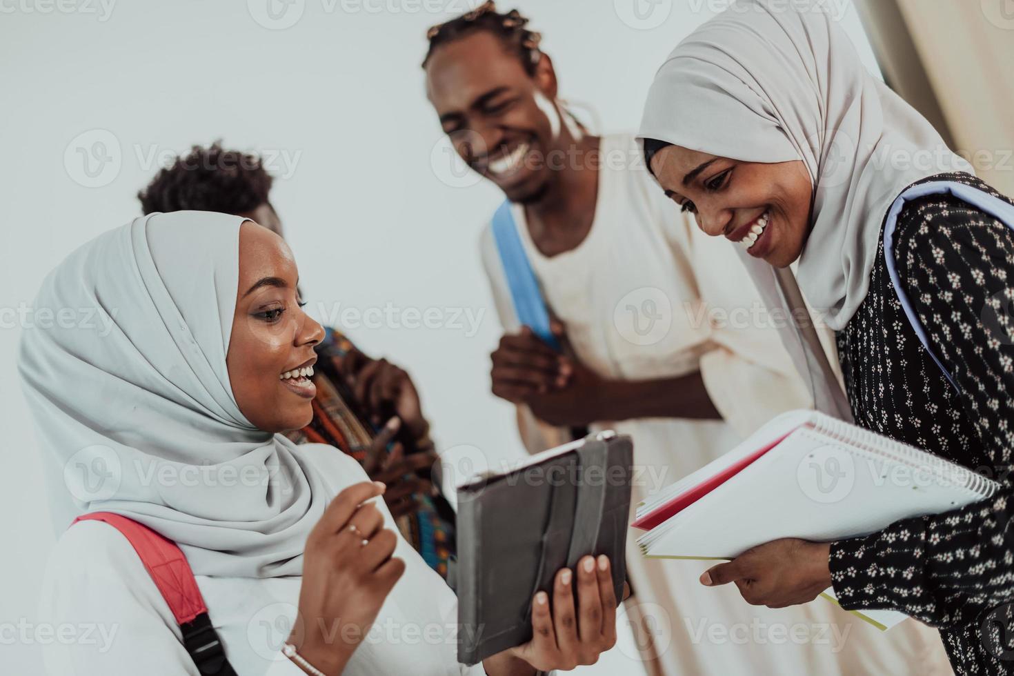 African female student with group of friends in background wearing traditional Islamic hijab clothes. Selectve focus photo