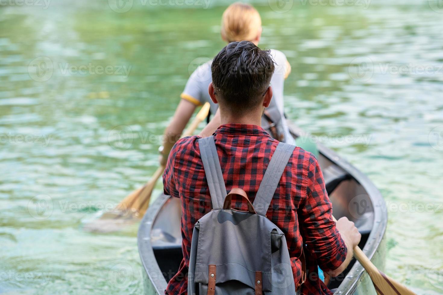 friends are canoeing in a wild river photo