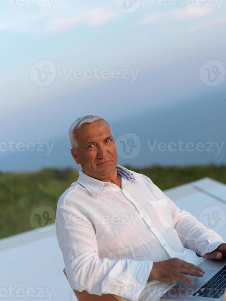 relaxed senior man on balcony photo