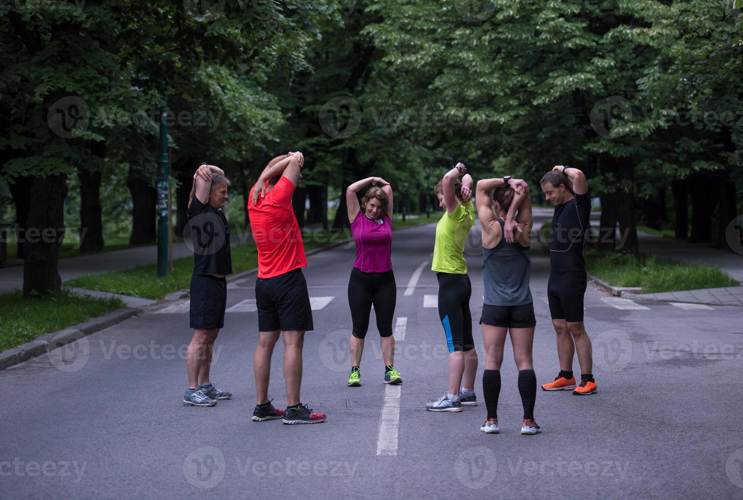 runners team warming up and stretching before morning training photo