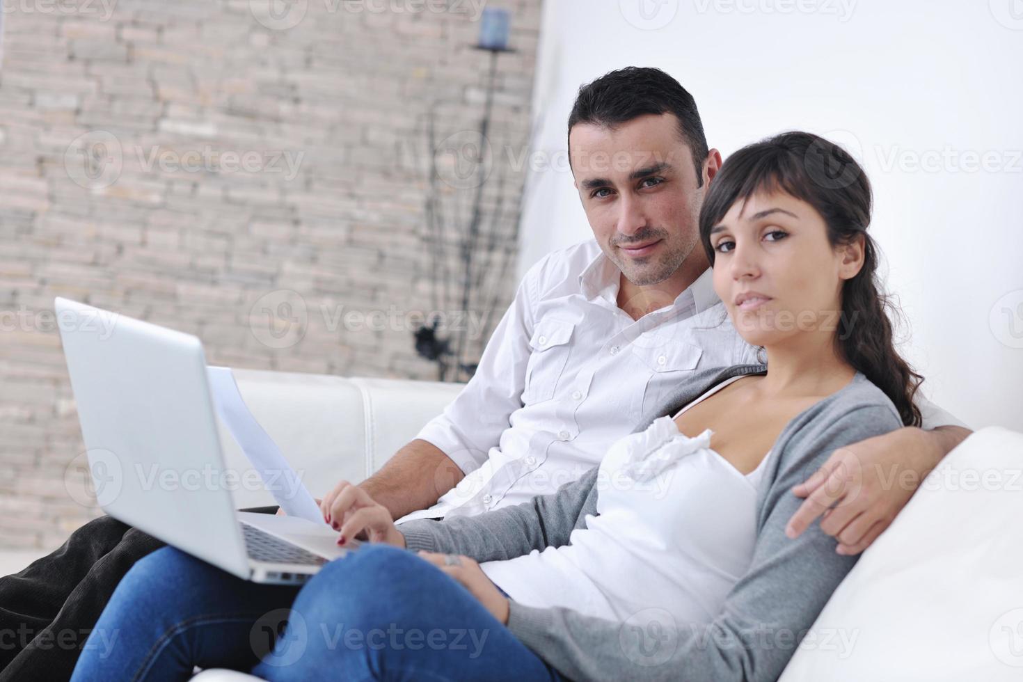 joyful couple relax and work on laptop computer at modern home photo