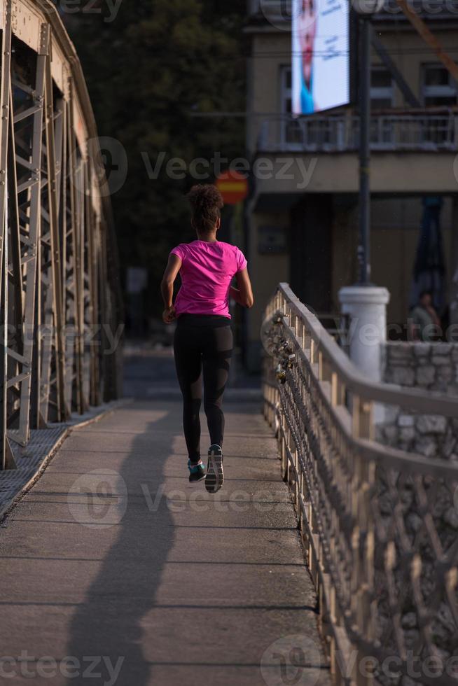 mujer afroamericana corriendo por el puente foto